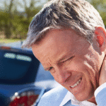 Man with neck pain standing next to Car Accident Chiropractor in Tulsa