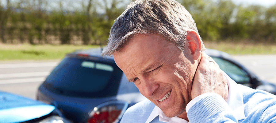 Man with neck pain standing next to Car Accident Chiropractor in Tulsa