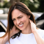 Woman with whiplash standing outside of her car after a car accident in Tulsa, OK