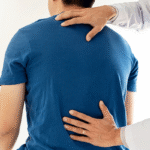 Chiropractor examining a man's back in Tulsa, OK