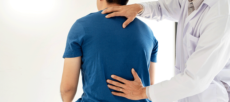 Chiropractor examining a man's back in Tulsa, OK