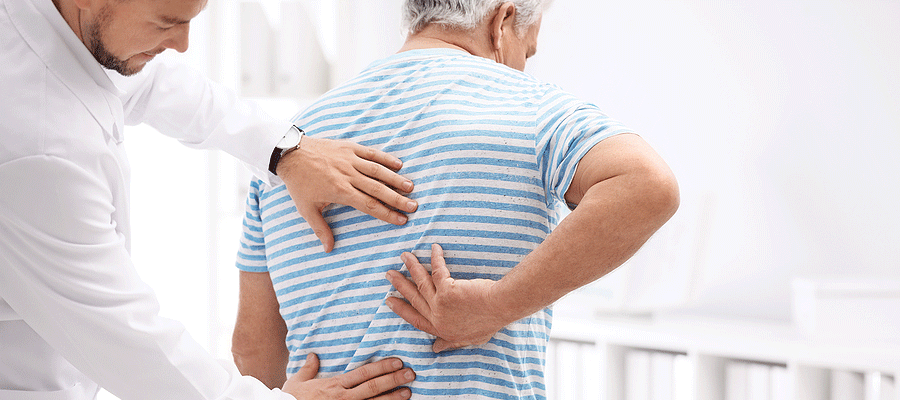 Chiropractor examining male patient with Back Pain in Tulsa, OK