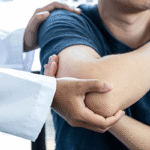 Chiropractor adjusting a man's shoulder and arm in Tulsa, OK