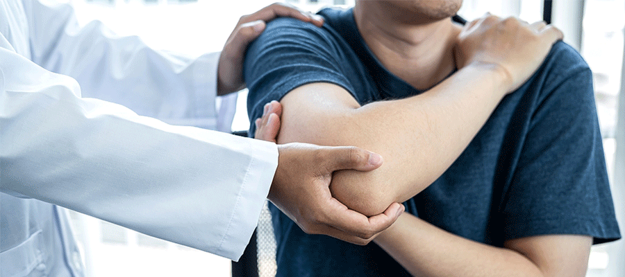 Chiropractor adjusting a man's shoulder and arm in Tulsa, OK
